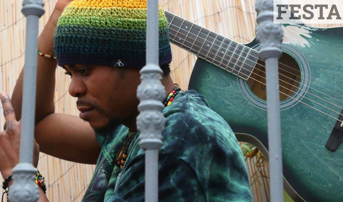 a man with a rainbow hat holding a guitar