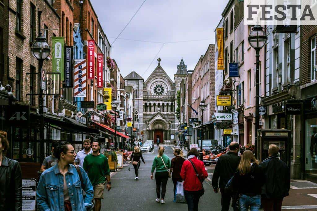 A bustling street scene in Dublin, showcasing diverse people and historic architecture.