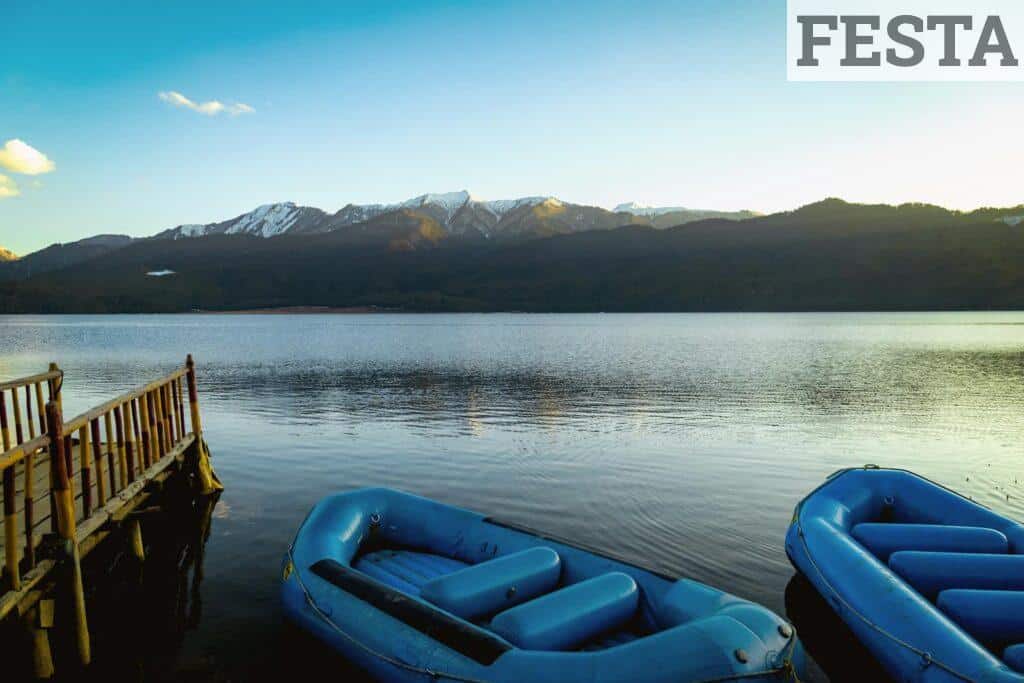 Peaceful scene of Rara Lake with blue inflatables and mountains in Nepal.