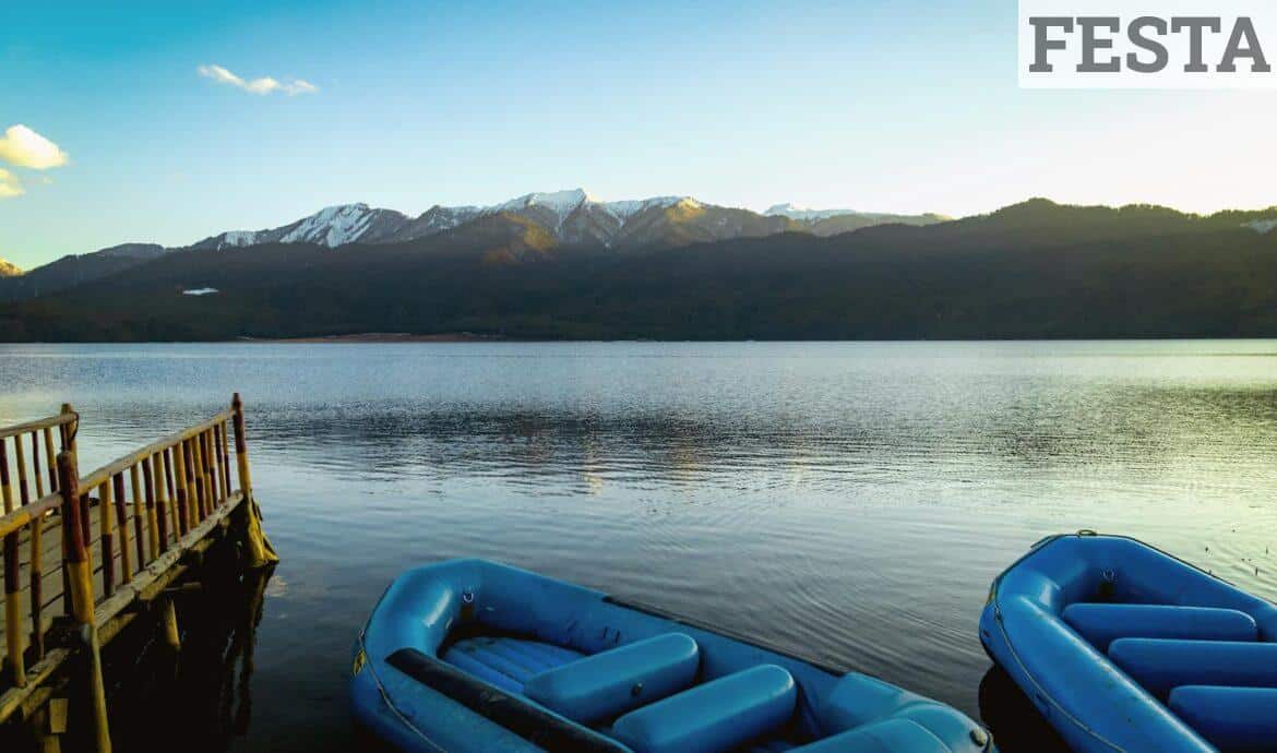 Peaceful scene of Rara Lake with blue inflatables and mountains in Nepal.