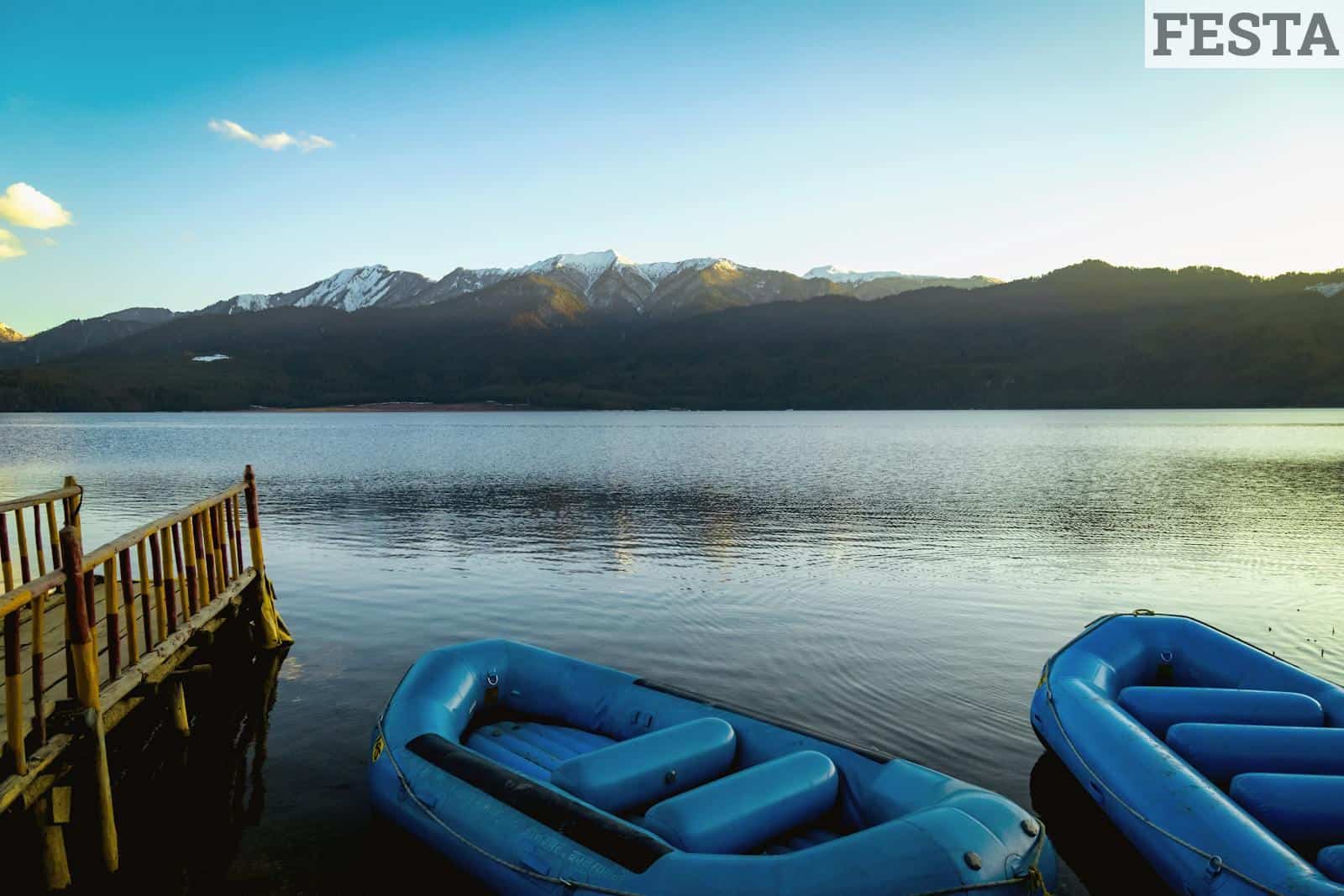 Peaceful scene of Rara Lake with blue inflatables and mountains in Nepal.